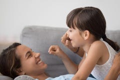 La maman espi?gle ont l'amusement jouant avec la petite fille mignonne images stock La maman espi?gle ont l'amusement jouant avec la petite fille mignonne images stock