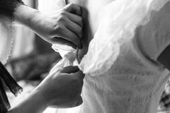 La maman ferme la fermeture éclair la robe l'épousant de la jeune mariée photo stock La maman ferme la fermeture éclair la robe l'épousant de la jeune mariée photo stock