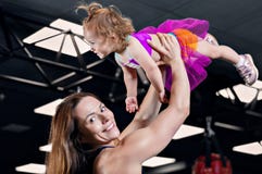 La mamá lanza a su hija para arriba en el gimnasio foto de archivo libre de regalías La mamá lanza a su hija para arriba en el gimnasio foto de archivo libre de regalías