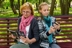 La mam? y la hija leyeron una revista en el parque imágenes de archivo libres de regalías La mam? y la hija leyeron una revista en el parque imágenes de archivo libres de regalías