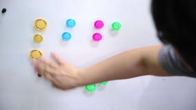 La mano categorizza il magnete colourful La mano categorizza il magnete colourful