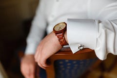 La mano del hombre con el primer elegante costoso del reloj Hombre de negocios joven acertado en una camisa blanca y un reloj de fotografía de archivo libre de regalías La mano del hombre con el primer elegante costoso del reloj Hombre de negocios joven acertado en una camisa blanca y un reloj de fotografía de archivo libre de regalías