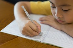 La mano del ragazzino sta scrivendo il compito a casa immagini stock La mano del ragazzino sta scrivendo il compito a casa immagini stock