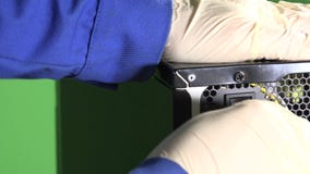 La mano del técnico en guantes enchufa el cable eléctrico a la PC y al botón metrajes La mano del técnico en guantes enchufa el cable eléctrico a la PC y al botón metrajes