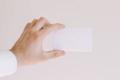 La mano dell'uomo in camicia bianca che mostra una carta in bianco immagine stock La mano dell'uomo in camicia bianca che mostra una carta in bianco immagine stock