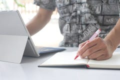La mano dell'uomo tiene la penna su un taccuino vuoto e su un taccuino fotografia stock libera da diritti La mano dell'uomo tiene la penna su un taccuino vuoto e su un taccuino fotografia stock libera da diritti