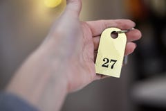 La mano della donna che tiene la chiave di camera di albergo fotografia stock libera da diritti La mano della donna che tiene la chiave di camera di albergo fotografia stock libera da diritti