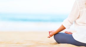 La mano della donna pratica l'yoga e medita su spiaggia immagine stock La mano della donna pratica l'yoga e medita su spiaggia immagine stock