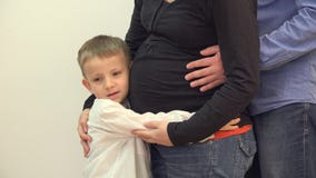 La mano feliz del niño y del padre abraza el vientre embarazada de la madre, detalle almacen de metraje de vídeo La mano feliz del niño y del padre abraza el vientre embarazada de la madre, detalle almacen de metraje de vídeo
