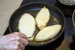 La mano femenina da vuelta a las tortas calientes en una cacerola con una bifurcación Placa de la estufa imagenes de archivo La mano femenina da vuelta a las tortas calientes en una cacerola con una bifurcación Placa de la estufa imagenes de archivo
