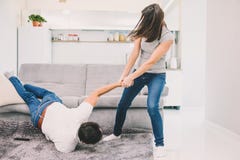 La moglie getta il suo marito dal sofà immagine stock La moglie getta il suo marito dal sofà immagine stock