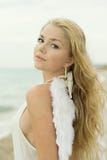La muchacha atractiva hermosa con las alas en la costa foto de archivo libre de regalías La muchacha atractiva hermosa con las alas en la costa foto de archivo libre de regalías