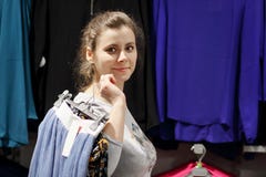 La muchacha en boutique de la moda consiguió la ropa y va al vestuario Concepto de las compras La mujer joven atractiva elige la foto de archivo libre de regalías La muchacha en boutique de la moda consiguió la ropa y va al vestuario Concepto de las compras La mujer joven atractiva elige la foto de archivo libre de regalías