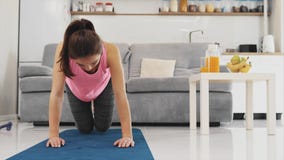 La muchacha está haciendo diligente los ejercicios para sus piernas almacen de metraje de vídeo La muchacha está haciendo diligente los ejercicios para sus piernas almacen de metraje de vídeo