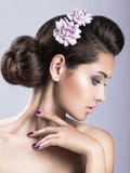 La muchacha hermosa con la piel perfecta y la púrpura florece en su cabeza fotos de archivo libres de regalías La muchacha hermosa con la piel perfecta y la púrpura florece en su cabeza fotos de archivo libres de regalías