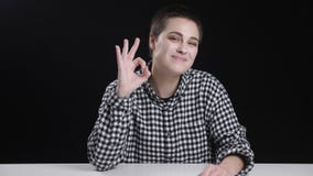 La muchacha joven del pelo corto muestra la muestra aceptable, sonriendo, riendo, fondo negro almacen de metraje de vídeo La muchacha joven del pelo corto muestra la muestra aceptable, sonriendo, riendo, fondo negro almacen de metraje de vídeo