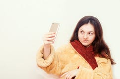 La muchacha morena joven en una albornoz hace el selfie en fondo aislado blanco Fotografía de archivo libre de regalías La muchacha morena joven en una albornoz hace el selfie en fondo aislado blanco Fotografía de archivo libre de regalías
