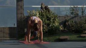 La muchacha rubia hace ejercicio de la yoga en terraza del tejado La muchacha rubia hace ejercicio de la yoga en terraza del tejado