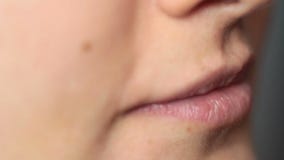La muchacha va con la lengua sobre la herida después de la extracción del diente almacen de metraje de vídeo La muchacha va con la lengua sobre la herida después de la extracción del diente almacen de metraje de vídeo