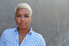 La mujer afroamericana joven hermosa con cortocircuito teñió el pelo rubio que miraba la cámara con una expresión neutral relajad fotografía de archivo libre de regalías La mujer afroamericana joven hermosa con cortocircuito teñió el pelo rubio que miraba la cámara con una expresión neutral relajad fotografía de archivo libre de regalías