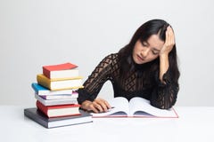 La mujer asiática joven agotada leyó un libro con los libros en la tabla imagen de archivo libre de regalías La mujer asiática joven agotada leyó un libro con los libros en la tabla imagen de archivo libre de regalías