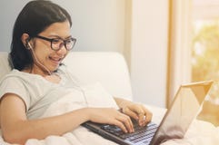 La mujer asiática sea feliz con el ordenador portátil y los auriculares imágenes de archivo libres de regalías La mujer asiática sea feliz con el ordenador portátil y los auriculares imágenes de archivo libres de regalías