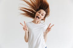 La mujer de griterío feliz en la camiseta que muestra paz gesticula foto de archivo La mujer de griterío feliz en la camiseta que muestra paz gesticula foto de archivo