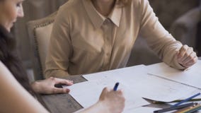La mujer de los diseñadores de Clother crea un bosquejo en el papel a su cliente en estudio del sastre almacen de video La mujer de los diseñadores de Clother crea un bosquejo en el papel a su cliente en estudio del sastre almacen de video