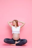 La mujer embarazada hermosa joven hace ejercicio de la yoga imagenes de archivo La mujer embarazada hermosa joven hace ejercicio de la yoga imagenes de archivo