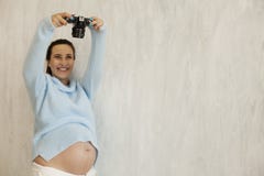 La mujer embarazada hermosa toma una imagen en la cámara foto de archivo libre de regalías La mujer embarazada hermosa toma una imagen en la cámara foto de archivo libre de regalías