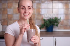 La mujer está bebiendo el smoothie sano fresco del arándano fotografía de archivo La mujer está bebiendo el smoothie sano fresco del arándano fotografía de archivo