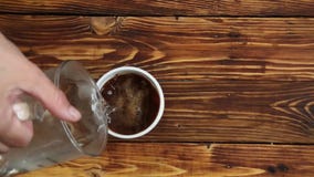 La mujer está vertiendo el agua hirvienda para ahuecar con el café instantáneo, cámara lenta metrajes La mujer está vertiendo el agua hirvienda para ahuecar con el café instantáneo, cámara lenta metrajes