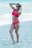 La mujer hermosa cuesta en la playa por el mar Fotografía de archivo libre de regalías La mujer hermosa cuesta en la playa por el mar Fotografía de archivo libre de regalías