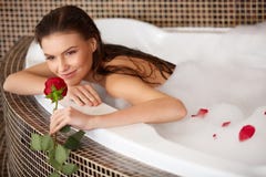 La mujer hermosa en baño con subió Cuidado de la carrocería foto de archivo La mujer hermosa en baño con subió Cuidado de la carrocería foto de archivo