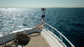 La mujer joven arma como las alas del pájaro en el barco del yate almacen de video La mujer joven arma como las alas del pájaro en el barco del yate almacen de video