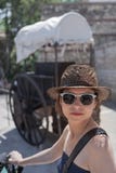 La mujer joven en las gafas de sol y el sombrero de paja fotos de archivo libres de regalías La mujer joven en las gafas de sol y el sombrero de paja fotos de archivo libres de regalías
