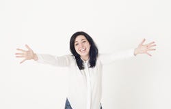 La mujer joven en una blusa blanca se está preparando para abrazar alguien, se está separando las manos de par en par aparte y es foto de archivo libre de regalías La mujer joven en una blusa blanca se está preparando para abrazar alguien, se está separando las manos de par en par aparte y es foto de archivo libre de regalías