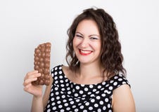 La mujer joven hermosa que come una barra de chocolate, lleva un vestido con los lunares imagenes de archivo La mujer joven hermosa que come una barra de chocolate, lleva un vestido con los lunares imagenes de archivo