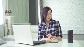 La mujer joven que estudia, usando un ayudante de la voz, tiene una pregunta La mujer joven que estudia, usando un ayudante de la voz, tiene una pregunta