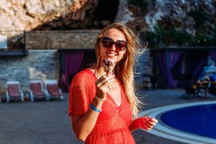 La mujer joven sonriente come el helado de chocolate en verano imagen de archivo libre de regalías La mujer joven sonriente come el helado de chocolate en verano imagen de archivo libre de regalías
