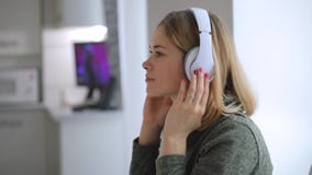 La mujer que relaja en casa buena música que escucha, viste los auriculares almacen de video La mujer que relaja en casa buena música que escucha, viste los auriculares almacen de video