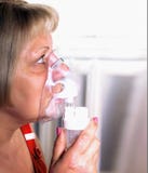 La mujer respira con un inhalador, el tratamiento de fríos y la tos fotografía de archivo libre de regalías La mujer respira con un inhalador, el tratamiento de fríos y la tos fotografía de archivo libre de regalías