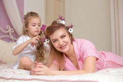La mère et la fille font des cheveux et ont l'amusement photos stock La mère et la fille font des cheveux et ont l'amusement photos stock