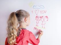 La ni?a dibuja a la familia con el marcador en un tablero blanco imagen de archivo libre de regalías La ni?a dibuja a la familia con el marcador en un tablero blanco imagen de archivo libre de regalías