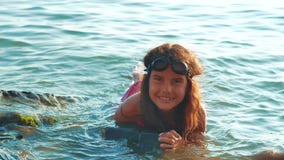 La ni?a se ba?a en el mar con las rocas y las piedras la hija adolescente de la muchacha nada en el agua en la forma de vida de l almacen de video La ni?a se ba?a en el mar con las rocas y las piedras la hija adolescente de la muchacha nada en el agua en la forma de vida de l almacen de video