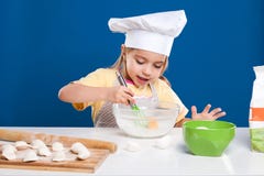 La niña es de cocinar y preparada la comida en fondo azul Imagen de archivo La niña es de cocinar y preparada la comida en fondo azul Imagen de archivo