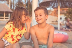La niña está susurrando un secreto en su oído de los amigos fotografía de archivo La niña está susurrando un secreto en su oído de los amigos fotografía de archivo