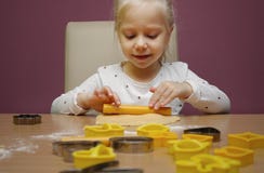 La niña hace una pasta fotografía de archivo La niña hace una pasta fotografía de archivo