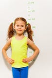 La niña hace una pausa la escala de medición de la altura fotografía de archivo La niña hace una pausa la escala de medición de la altura fotografía de archivo