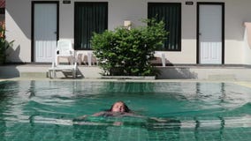 La niña salta en una piscina tiempo funy en vacaciones de verano almacen de video La niña salta en una piscina tiempo funy en vacaciones de verano almacen de video